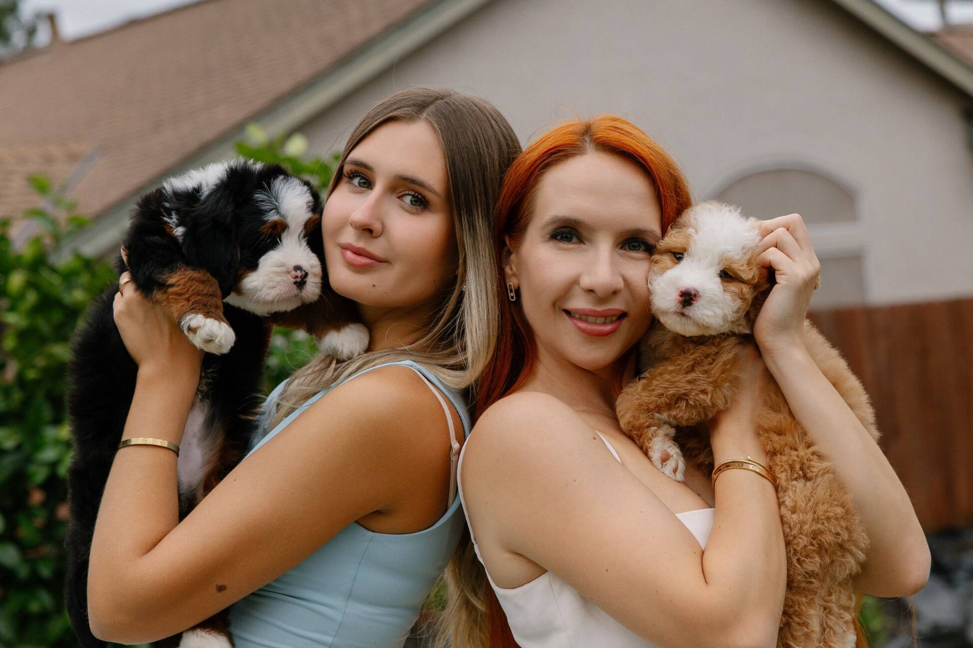 red hair woman holding a bernedoodle puppy